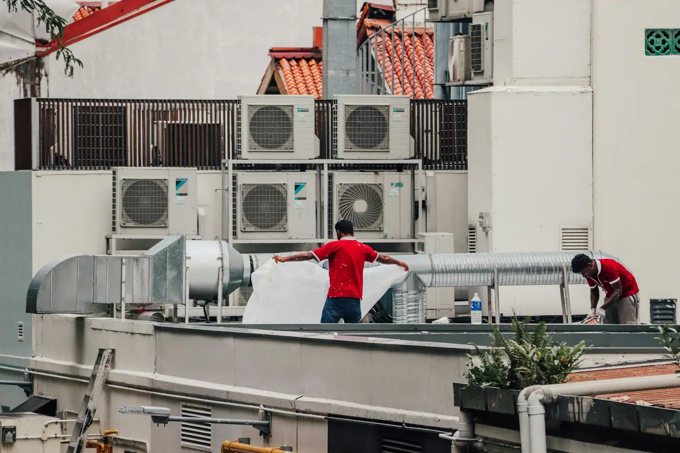 Technician carrying out preventive maintenance on rooftop AC units